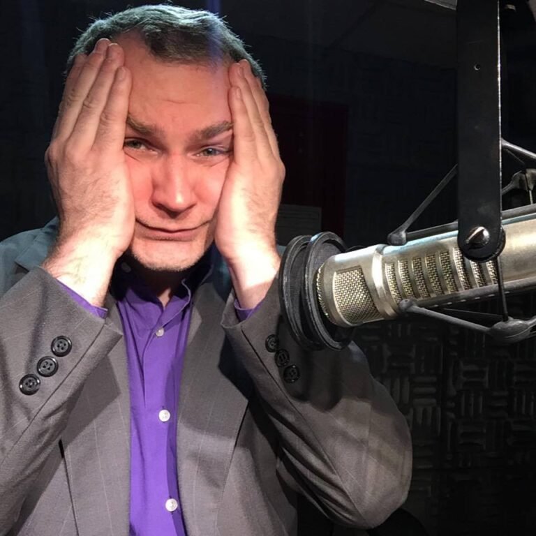 paul leary hands on face grey suitecoat